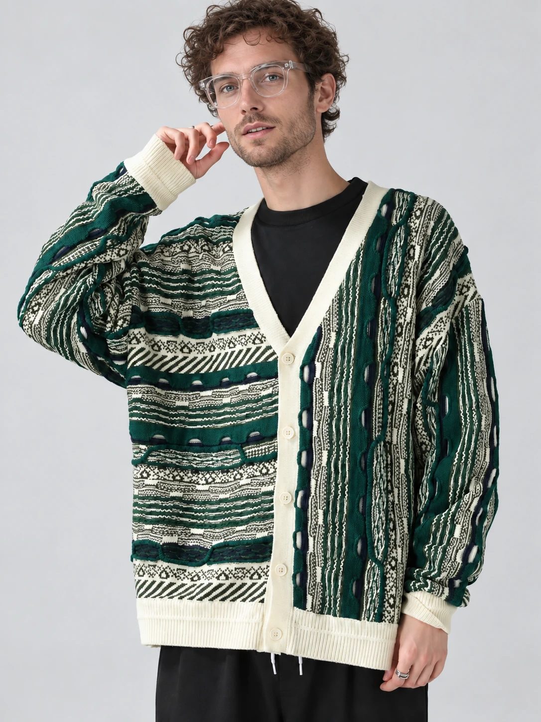 Man wearing a green and cream V-neck cardigan with asymmetric horizontal and vertical front patterns and cream ribbed bands