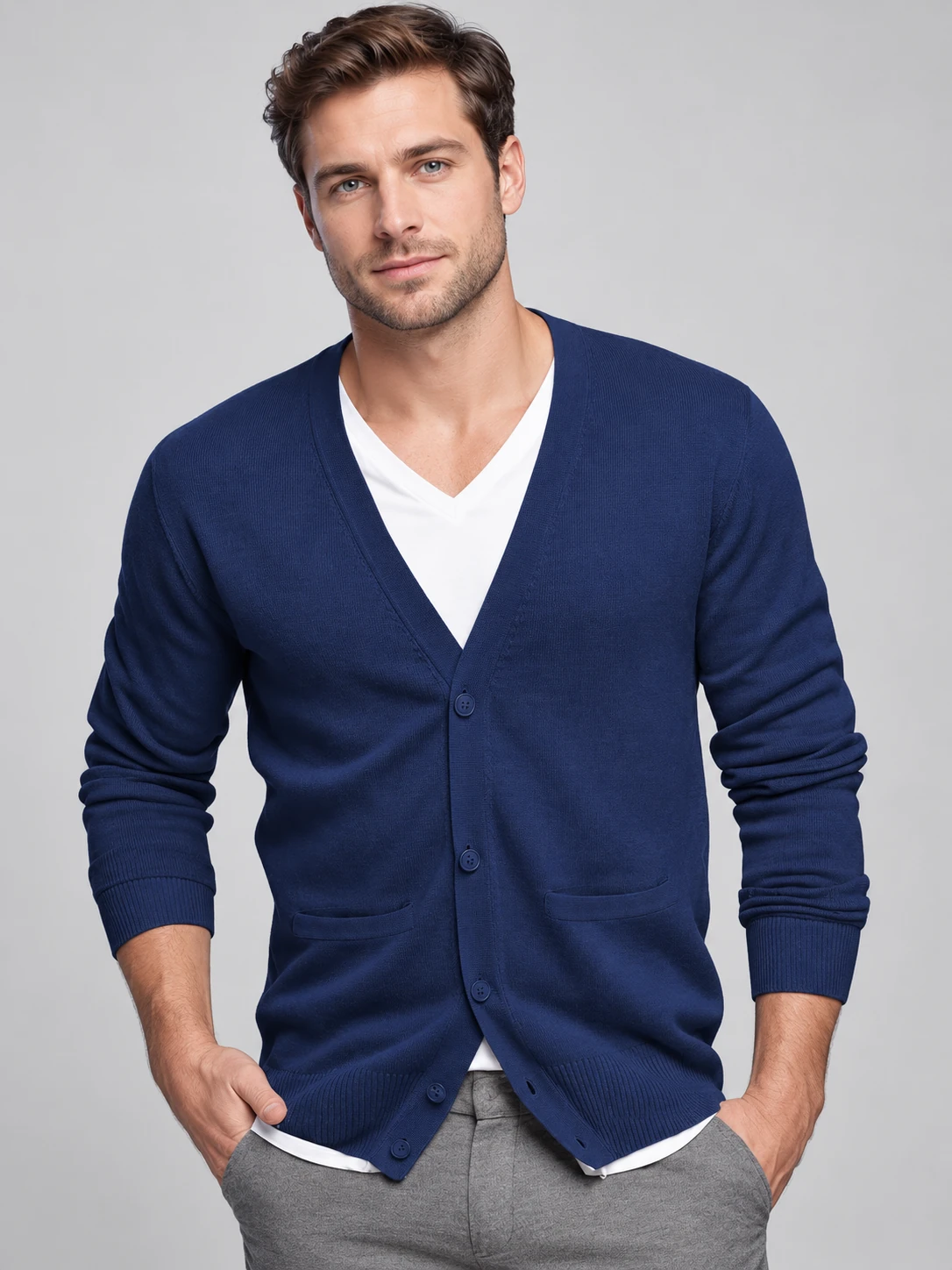 Man wearing a navy V-neck button cardigan with two front patch pockets and ribbed cuffs and hem