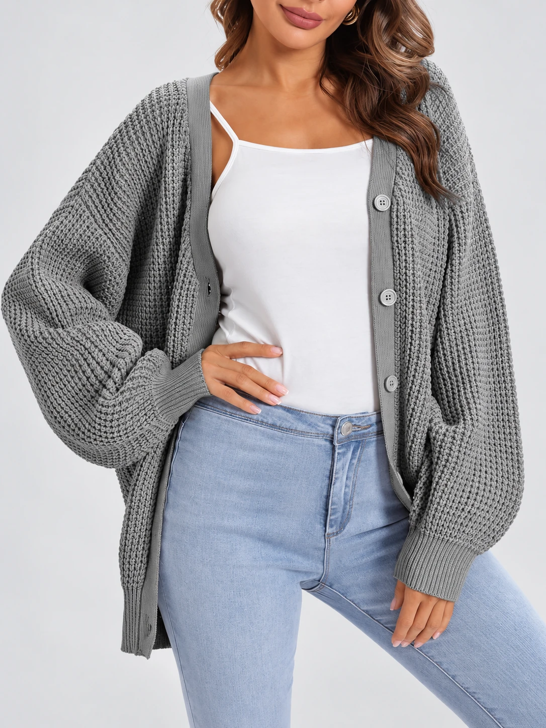 Woman wearing a gray textured cardigan with front buttons and ribbed cuffs